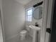 Updated bathroom with pedestal sink, toilet and modern vanity at 5198 40Th S St, St Petersburg, FL 33711