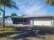 Newly renovated home featuring a blue exterior, white garage door, and palm trees at 5198 40Th S St, St Petersburg, FL 33711