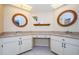 Bathroom featuring dual vanities, mirrors, and bright lighting at 7065 Sparkling Creek Ct, Spring Hill, FL 34606