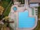 Aerial view of a swimming pool and hot tub surrounded by lounge chairs at 7065 Sparkling Creek Ct, Spring Hill, FL 34606