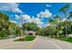 Gated entrance to the community with lush landscaping and a guardhouse at 7065 Sparkling Creek Ct, Spring Hill, FL 34606