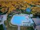 Aerial view of the community swimming pool with surrounding tennis courts and neighborhood homes at 7065 Sparkling Creek Ct, Spring Hill, FL 34606