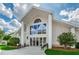 Exterior shot of the community clubhouse featuring tall columns and lots of natural light at 7065 Sparkling Creek Ct, Spring Hill, FL 34606