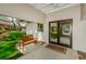 Inviting entryway featuring glass doors, a wooden bench, and a well-manicured lawn at 7065 Sparkling Creek Ct, Spring Hill, FL 34606