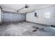 Spacious two-car garage with concrete flooring, overhead door and side door at 7065 Sparkling Creek Ct, Spring Hill, FL 34606