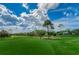 Scenic view of the golf course with green grass and a blue cloudy sky in the background at 7065 Sparkling Creek Ct, Spring Hill, FL 34606