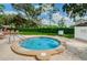 Inviting hot tub on a sunny day, surrounded by lush landscaping and comfortable seating at 7065 Sparkling Creek Ct, Spring Hill, FL 34606