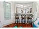 Kitchen features a breakfast bar with three stools, granite countertop, and view into kitchen at 764 Captiva Ne Ct, St Petersburg, FL 33702