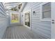 Long screened porch with white walls and wooden flooring at 764 Captiva Ne Ct, St Petersburg, FL 33702