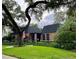 Brick home with black roof, landscaping, and American flag at 807 Grove Park Ave, Tampa, FL 33609