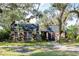 Brick home with black roof, mature landscaping, and large trees at 807 Grove Park Ave, Tampa, FL 33609