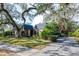 Brick home with paver driveway, lush landscaping, and mature trees at 807 Grove Park Ave, Tampa, FL 33609