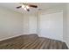 Bedroom with wood-look floors, ceiling fan, and double door closet at 849 Haleybury St, Port Charlotte, FL 33948