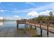 Wooden dock extending over calm water with houses in the background at 8565 W Gulf Blvd # 17S, Treasure Island, FL 33706
