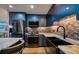 Modern kitchen with blue cabinets, marble island, and stainless steel appliances at 8565 W Gulf Blvd # 17S, Treasure Island, FL 33706