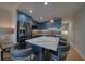 Modern kitchen with blue cabinets, marble island, and stainless steel appliances at 8565 W Gulf Blvd # 17S, Treasure Island, FL 33706