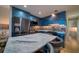 Modern kitchen with blue cabinets, marble island, and stainless steel appliances at 8565 W Gulf Blvd # 17S, St Petersburg, FL 33706