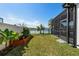 Landscaped backyard with a raised garden bed and screened enclosure at 8621 Ivy Stark Blvd, Wesley Chapel, FL 33545