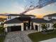 Stunning two-story home with a modern design, featuring a three-car garage and landscaped yard at 8621 Ivy Stark Blvd, Wesley Chapel, FL 33545
