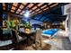 Covered patio with fire pit and comfortable seating near the pool at 8621 Ivy Stark Blvd, Wesley Chapel, FL 33545