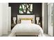 Bedroom with a queen bed, nightstands, and dark-green accent wall at 9404 Runaway Breeze Dr, Land O Lakes, FL 34637