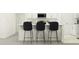 Kitchen features a white island with three black barstools at 9404 Runaway Breeze Dr, Land O Lakes, FL 34637