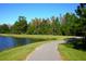 Paved path winds along a tranquil lake and lush greenery at 9404 Runaway Breeze Dr, Land O Lakes, FL 34637