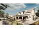 White farmhouse with metal roof, surrounded by lush landscaping and gardens at 9706 Minnow Ray Dr, Land O Lakes, FL 34638