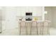 White kitchen with a breakfast bar and gold stools at 9706 Minnow Ray Dr, Land O Lakes, FL 34638