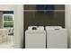 Bright laundry room with washer, dryer, and shelving at 9706 Minnow Ray Dr, Land O Lakes, FL 34638