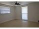 Bright bedroom featuring tile flooring, ceiling fan, and natural light from large windows at 7534 Mako Dr, Hudson, FL 34667