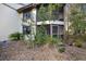 Exterior view of the condo with a screened porch and landscaping at 113 Woodlake Wynde # 19, Oldsmar, FL 34677