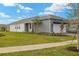 One-story home with gray and white exterior, landscaping, and a paved driveway at 11482 Boundless Ter, Venice, FL 34293