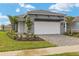 One-story home with gray siding, white garage door, and landscaped yard at 11482 Boundless Ter, Venice, FL 34293