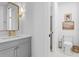 Stylish powder room featuring gray vanity with gold fixtures, complementing the modern toilet and decor at 120 25Th N Ave, St Petersburg, FL 33704