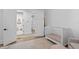 Bright bedroom with adjacent bathroom, showcasing a crib, rug, and seamless transition between spaces at 120 25Th N Ave, St Petersburg, FL 33704