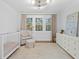 Well-lit Bedroom featuring a crib, comfortable chair, and elegant dresser, creating a serene atmosphere at 120 25Th N Ave, St Petersburg, FL 33704