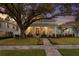 Charming home featuring a covered front porch, manicured lawn, and mature trees at 120 25Th N Ave, St Petersburg, FL 33704