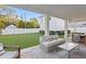 Open-air patio area has comfortable couch, brick flooring, and a landscaped yard with a white privacy fence at 120 25Th N Ave, St Petersburg, FL 33704