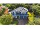 Blue house with tile roof, two-car garage, and manicured lawn at 12833 Darby Ridge Dr, Tampa, FL 33624