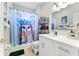 Clean bathroom with white vanity, shower/tub combo, and shelving at 12833 Darby Ridge Dr, Tampa, FL 33624