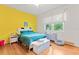 Bedroom with yellow wall and hardwood floors, featuring a double bed at 12833 Darby Ridge Dr, Tampa, FL 33624