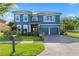 Two-story house featuring a blue exterior, paved driveway, and manicured landscaping at 12833 Darby Ridge Dr, Tampa, FL 33624