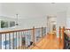 Upstairs hallway with hardwood floors and wrought-iron railing at 12833 Darby Ridge Dr, Tampa, FL 33624