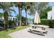 Community patio with table, umbrella, and pond view at 1398 Shady Pine Way # E3, Tarpon Springs, FL 34688