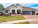 Two-story house with a three-car garage and lush landscaping at 14214 Quintessa Ln, Lithia, FL 33547