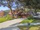 Two-story home with wood siding, mature landscaping, and a driveway at 1455 Briarwood Ct, Safety Harbor, FL 34695