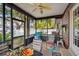 Cozy screened porch with seating area and ceiling fan at 1455 Briarwood Ct, Safety Harbor, FL 34695