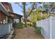 Side yard with AC units and a pathway leading to the backyard at 1455 Briarwood Ct, Safety Harbor, FL 34695