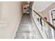 Gray carpeted staircase with wooden handrail at 1455 Briarwood Ct, Safety Harbor, FL 34695